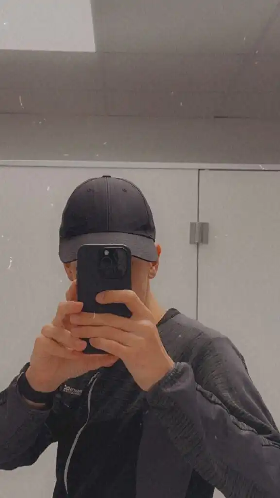 Spiegelbild von Adrian Dylan Wulf mit Kappe und Smartphone